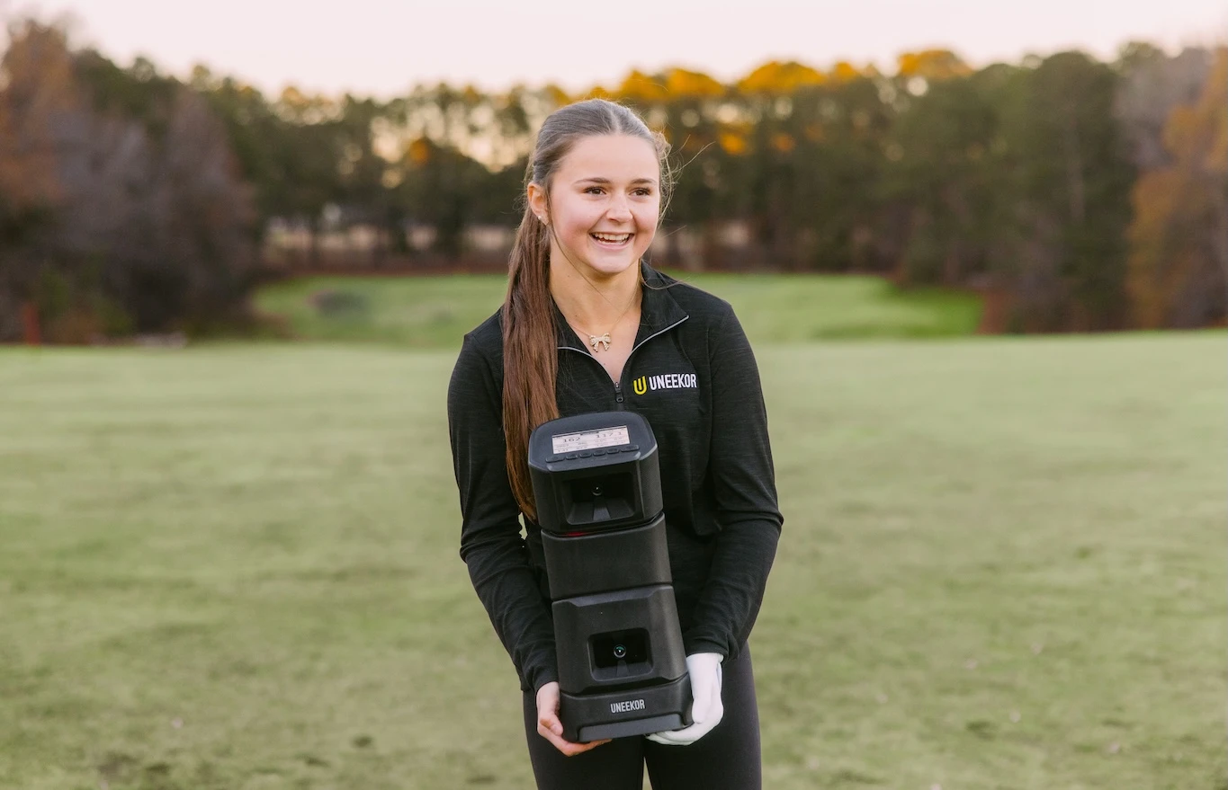Young girl holding Uneekor EYE MINI Launch Monitor