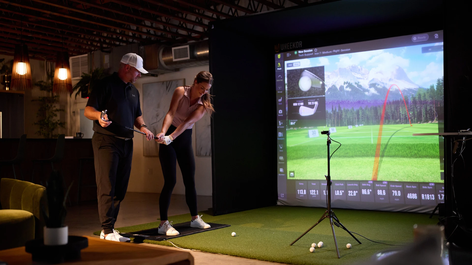 Golfer with trainer playing on Uneekor SIMKIT
